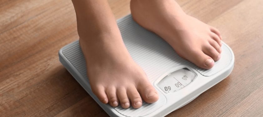 Overweight boy using scales at home Overweight boy using scales at home