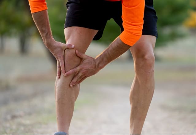 Runner holding painful knee.