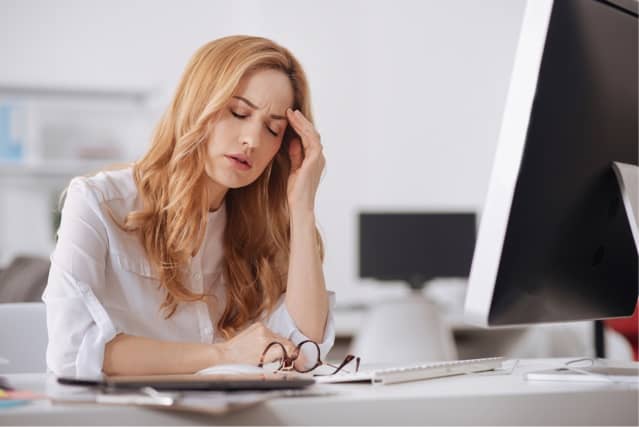 Woman experiencing chronic fatigue symptoms in the office.