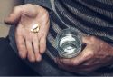 An elderly man takes pills with a glass of water.