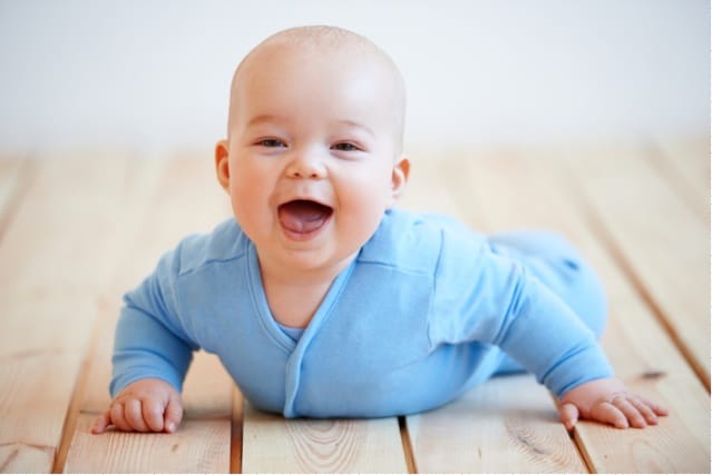 Happy baby crawling on the floor.