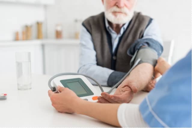 Older man getting blood pressure checked.
