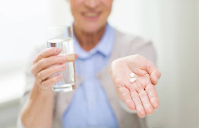 Elderly woman taking medications.