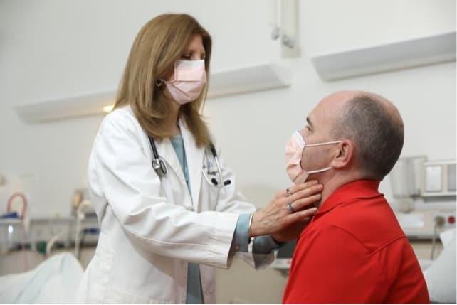 NIDCR researcher examining the neck of a clinical trial participant.
