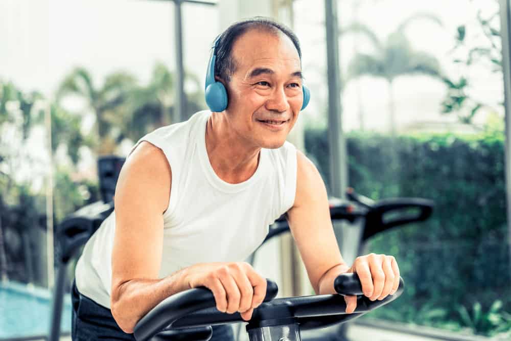 Senior man exercising on cycling machine.