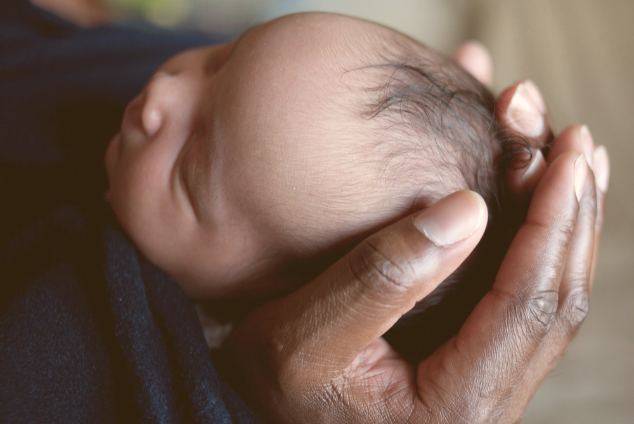 Black father holding newborn baby.