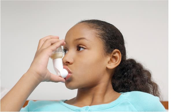 Girl using an asthma inhaler.