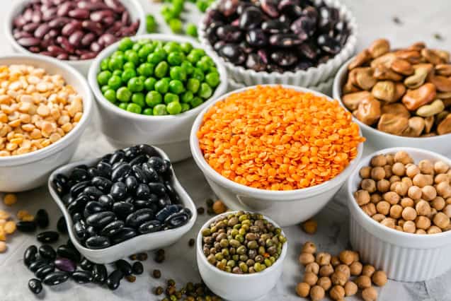 Selection of legumes in white bowls.