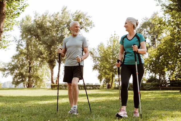 Older couple practicing nordic walking.