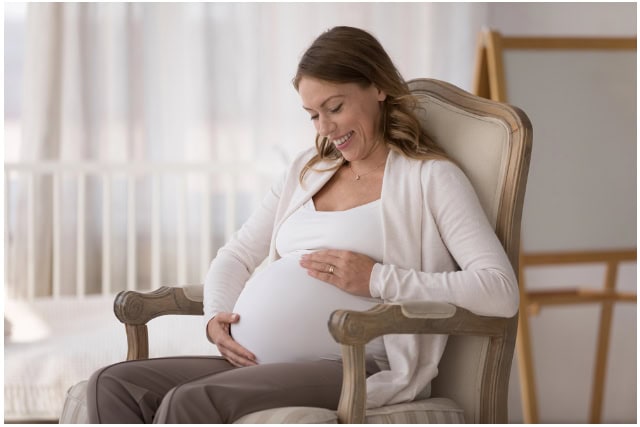 Pregnant woman sitting on a chair.
