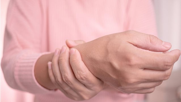 Woman holding painful wrist.