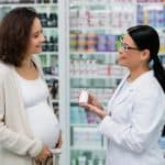 Pregnancy woman talking to a pharmacist.