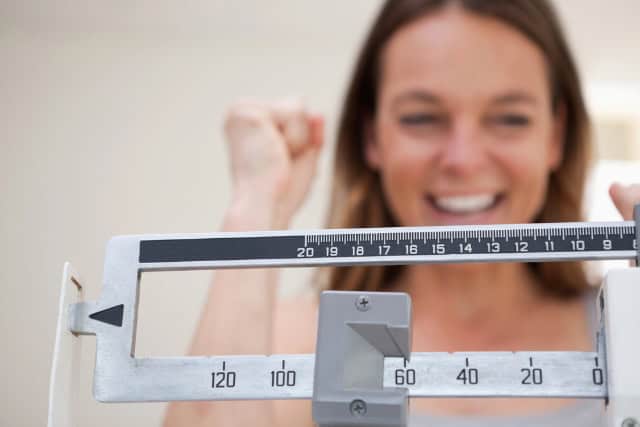 Woman using a weighing scale.