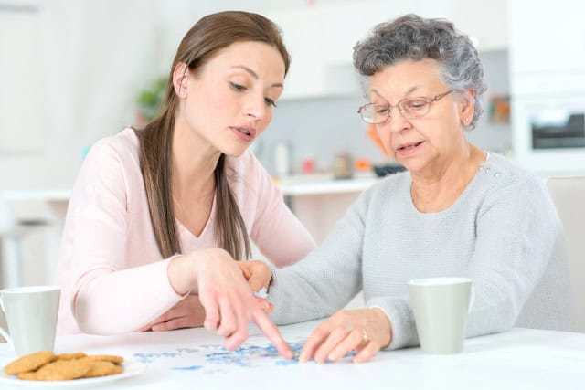 Elderly lady doing a jigsaw puzzle.