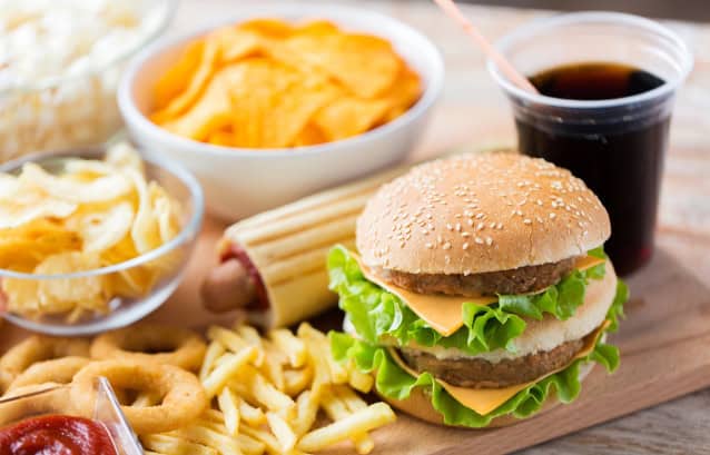 Close up of fast food snacks and drink on table.