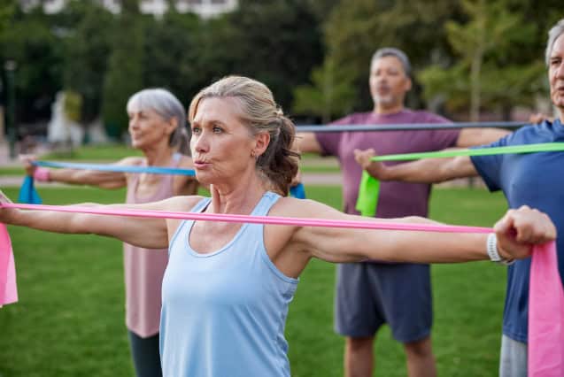A group of older adults exercising outdoors.